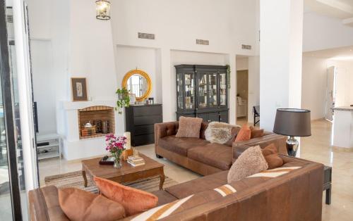 a living room with two brown couches and a fireplace at Casa Trebol - Private Pool Villa in San Javier