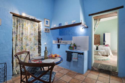 a blue room with a table and a kitchen at El Piccolo in Mácher