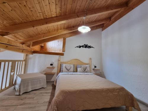 a bedroom with a bed in a room with wooden ceilings at Appartamento Adamello 5 in Pinzolo