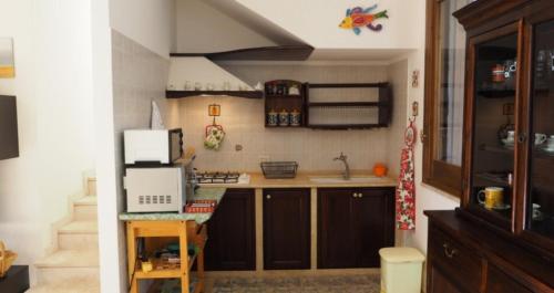 a small kitchen with a sink and a microwave at Villetta Vittoria in Macari