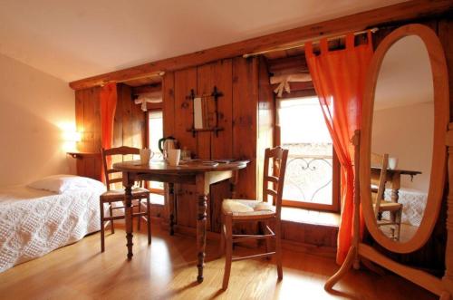 a bedroom with a table and a mirror and a bed at La Gourmantine in Polignac