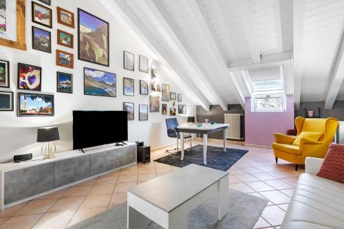 a living room with a tv and a couch and a table at Mema Holiday Home in Aosta