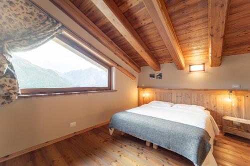 a bedroom with a bed and a large window at Civico 13 in Marmora