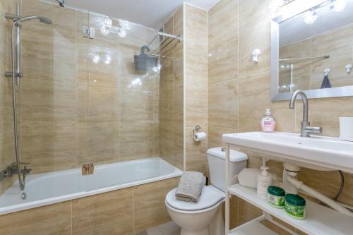 a bathroom with a tub and a toilet and a sink at Casa Alvates in Corralejo