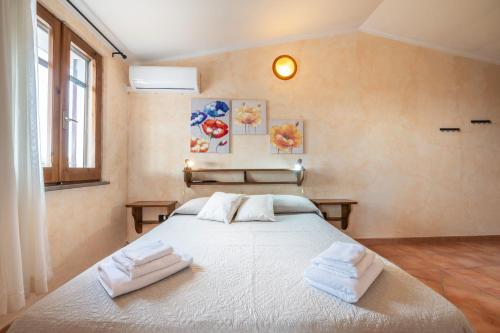a bedroom with a large bed with towels on it at Brezza di Mare in Calasetta