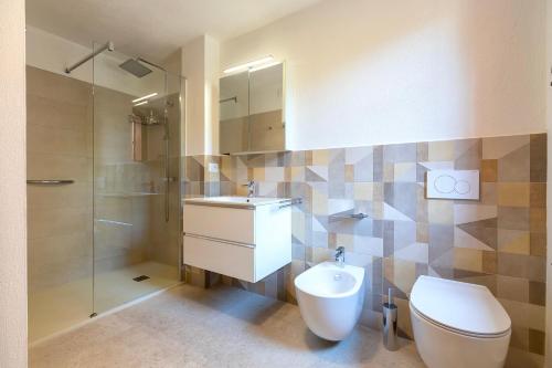 a bathroom with a toilet and a sink and a shower at Villa Grecale in Stintino