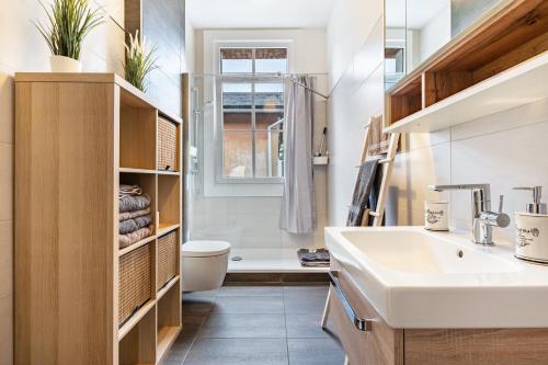 ein Badezimmer mit Waschbecken, Toilette und Fenster in der Unterkunft Quartier in Lauta