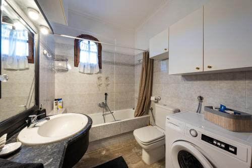 a bathroom with a sink and a washing machine at House Theodora holidays Greece in Dragotiná