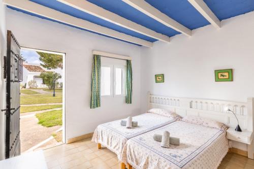 a white bedroom with a bed and a large window at Cala Serena Beach 5 in Felanitx