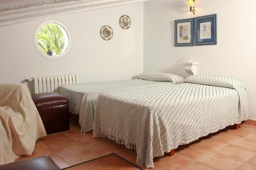a bedroom with a bed and a chair at Las Tórtolas in Alaior