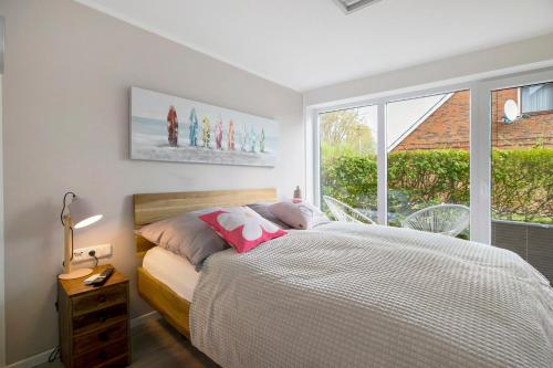 a bedroom with a bed and a large window at Ferienhaus Schleibengel in Maasholm