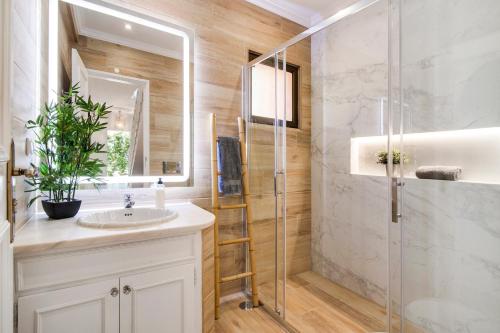 a bathroom with a sink and a glass shower at Sunshine House in Faro