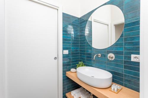 a blue tiled bathroom with a sink and a mirror at Taormina Center Suite in Taormina