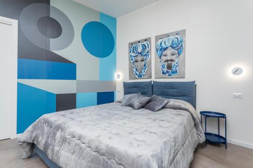 a bedroom with a bed with two posters on the wall at Taormina Center Suite in Taormina