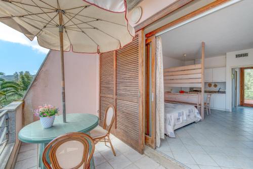 a bedroom with a table and an umbrella and a bed at Appartamenti Dolores in Campo nell'Elba