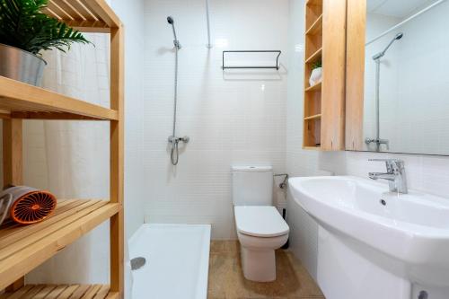 a bathroom with a white toilet and a sink at Loft Sant Joan in L'Ametlla de Mar