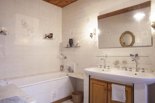 a bathroom with a sink and a tub and a mirror at Maison à Sigean in Sigean