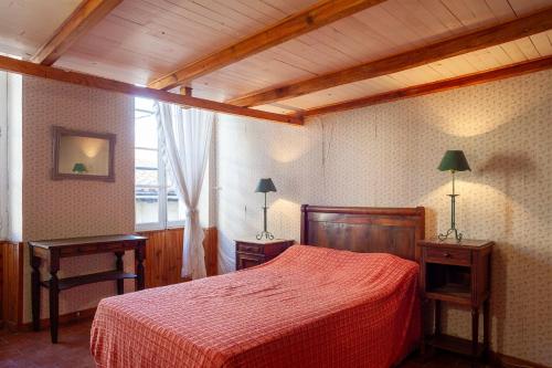 a bedroom with a red bed with two tables and a window at Maison à Sigean in Sigean