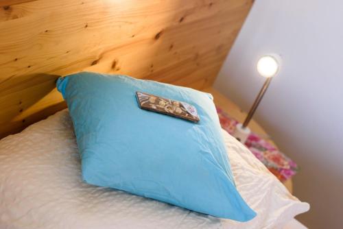 a blue pillow sitting on top of a bed at Peter Paul Studio Penegal in Appiano sulla Strada del Vino