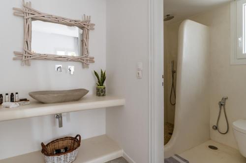 a bathroom with a sink and a mirror at Aeolos Thalia Suite in Agkidia