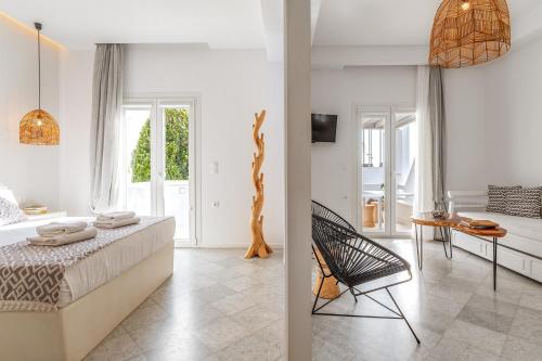 a bedroom with a bed and a table and a chair at Aeolos Thalia Suite in Agkidia