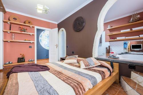 two beds in a bedroom with an arched window at Spr Ático in Santa Úrsula