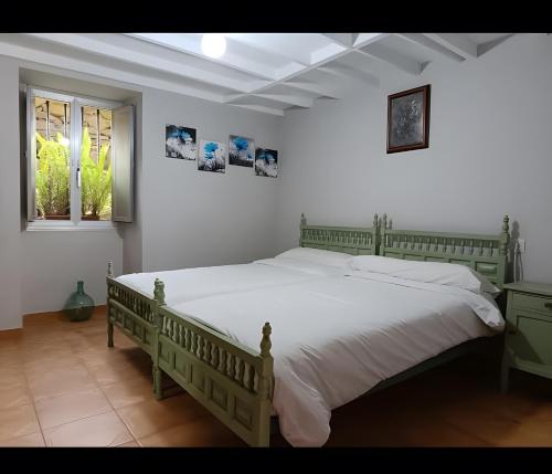 a bedroom with a large bed with white sheets at O Lar de Natalio in Rianjo