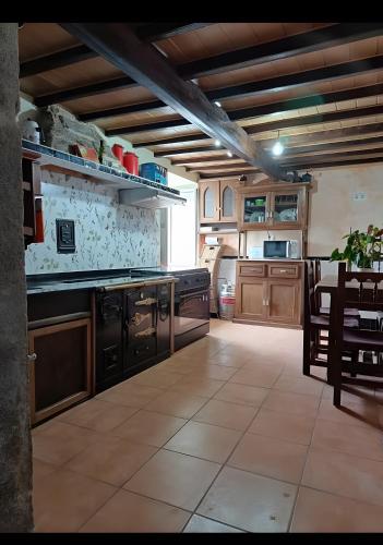 a large kitchen with wooden cabinets and a table at O Lar de Natalio in Rianjo