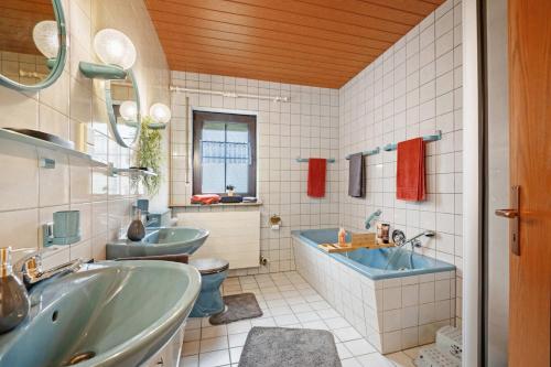 a bathroom with two sinks and a tub and a toilet at Betty’s Home in Gersheim