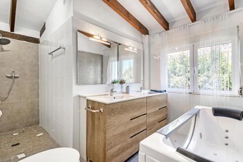 a bathroom with a tub and a sink and a toilet at Adriana in Denia