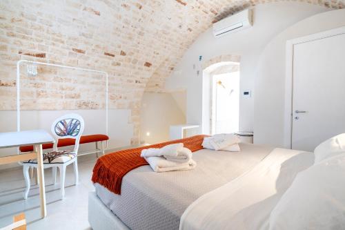 a white bedroom with a bed and a desk at Civico40 Suite in Locorotondo