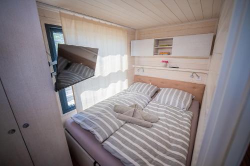 a small bed in a trailer with towels on it at Wohlfühl-Hausboot Elements Woma D13 in Fürstenberg