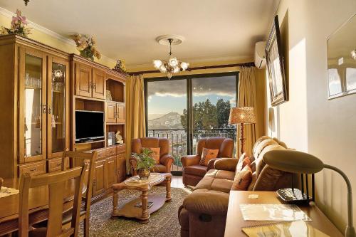 a living room with a couch and a table at Palheiro Residence Familiar 2 in Funchal