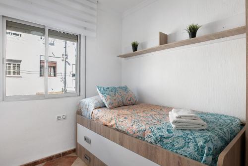 a small bedroom with a bed and a window at Apartamento Faro de Barbate in Barbate