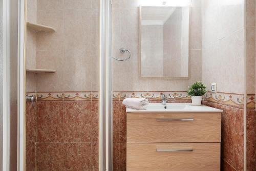a bathroom with a shower with a sink and a mirror at Apartamento Faro de Barbate in Barbate