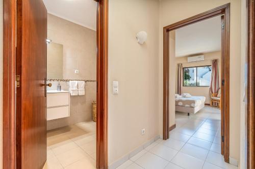 a bathroom with a door open to a bathroom with a sink at Norah’s House in Carvoeiro