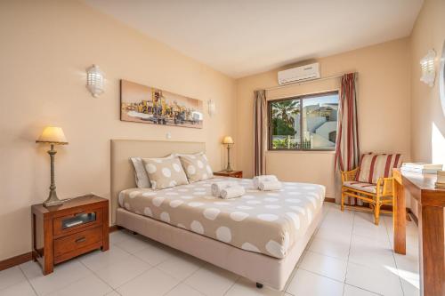 a bedroom with a bed and a desk and a window at Norah’s House in Carvoeiro