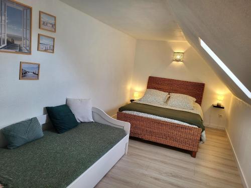 a small bedroom with a bed and a couch at Escapade Pirouaise - la Salicorne in Pirou