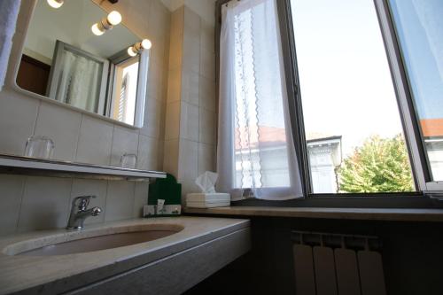 a bathroom with a sink and a mirror and a window at Il Giardinetto in Vercelli