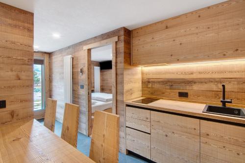 a kitchen with wooden walls and a sink at Agriturismo Montespluga in Madesimo