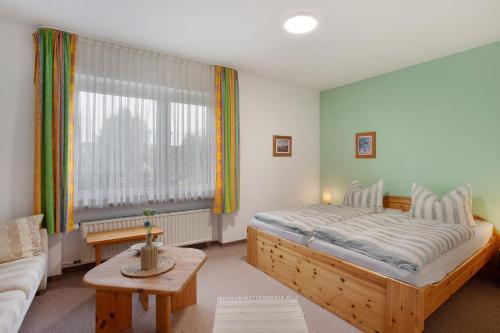 a bedroom with a bed and a couch and a table at Birkenhauer inkl Meine Card plus in Willingen
