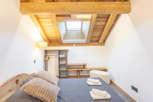 a bedroom with a bed and a wooden ceiling at Charlotte la Marmotte in Morillon