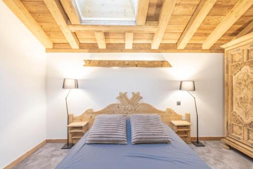 a bedroom with a large bed with two lamps at Charlotte la Marmotte in Morillon