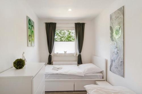 a bedroom with a bed and a window at Smolly's Ferienwohnung in Bad Zwischenahn