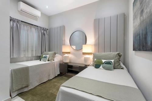 a bedroom with two beds and a mirror at Fantastic Villa Verano in San Miguel de Abona