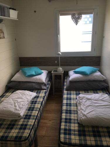 two beds in a room with a window at Chalet Strandliebe Bredene in Bredene