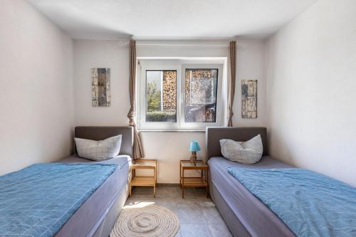 two beds in a room with two windows at Fewo Aida in Stockach