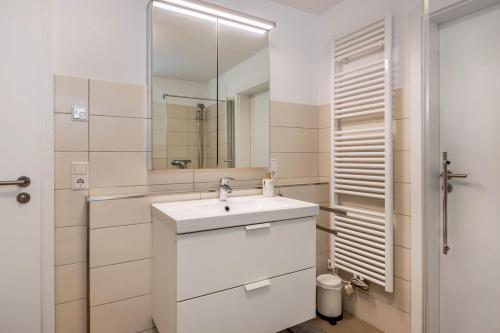 a white bathroom with a sink and a mirror at Fewo Aida in Stockach