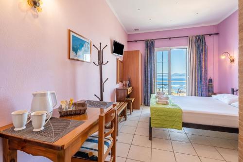 a hotel room with a bed and a dining table at Stefanos place Studio sea View 7 in Corfu