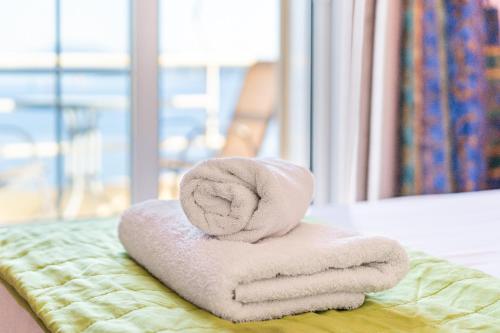 a stack of towels sitting on a bed at Stefanos place Studio sea View 7 in Corfu